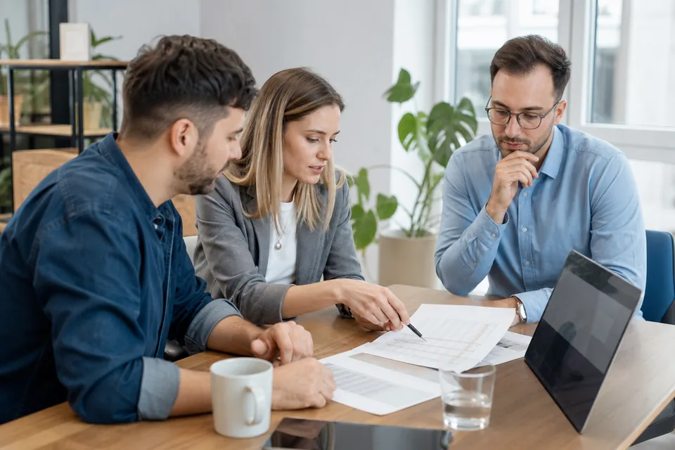 Zespół marketingu porównuje przy stole ofertę agencji z tabelą cen i budżetem kampanii